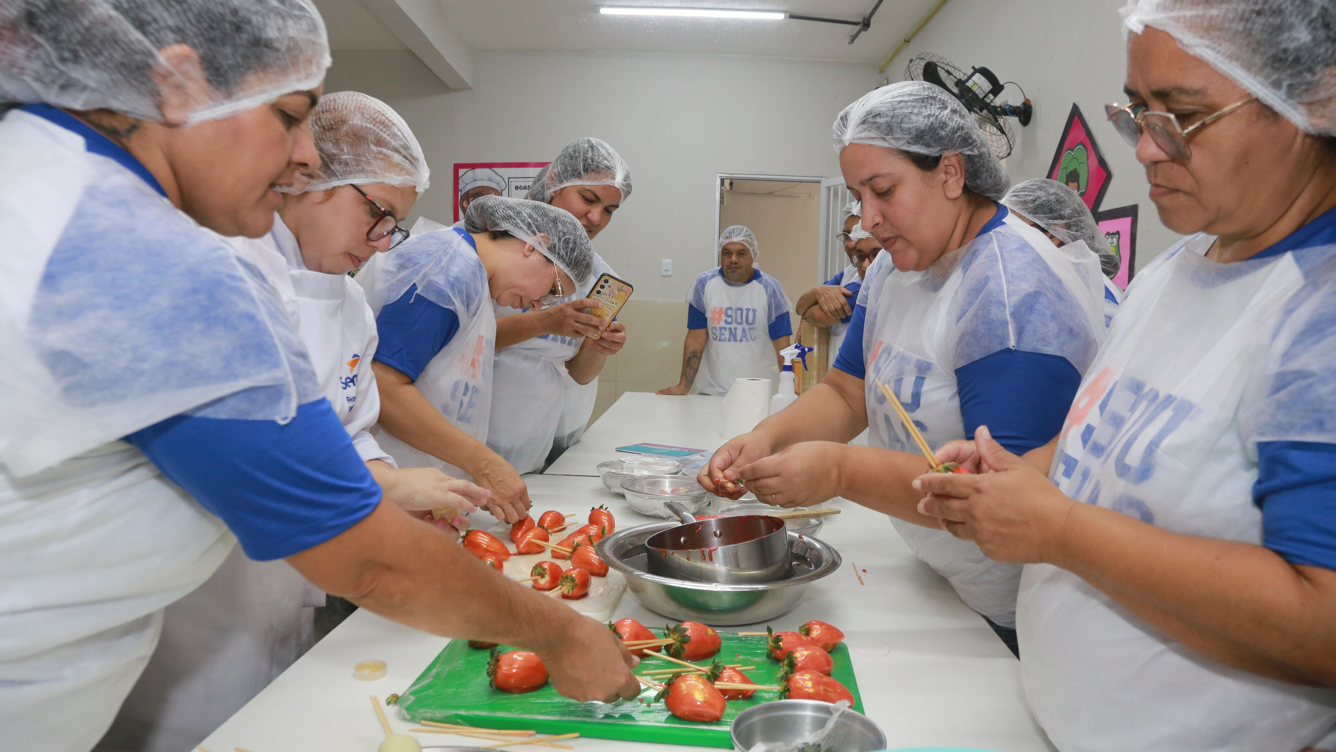 Alunas do curso de sobremesas comerciais do programa Fortaleza Inclusiva aprendem a fazer morango do amor em aula de encerramento